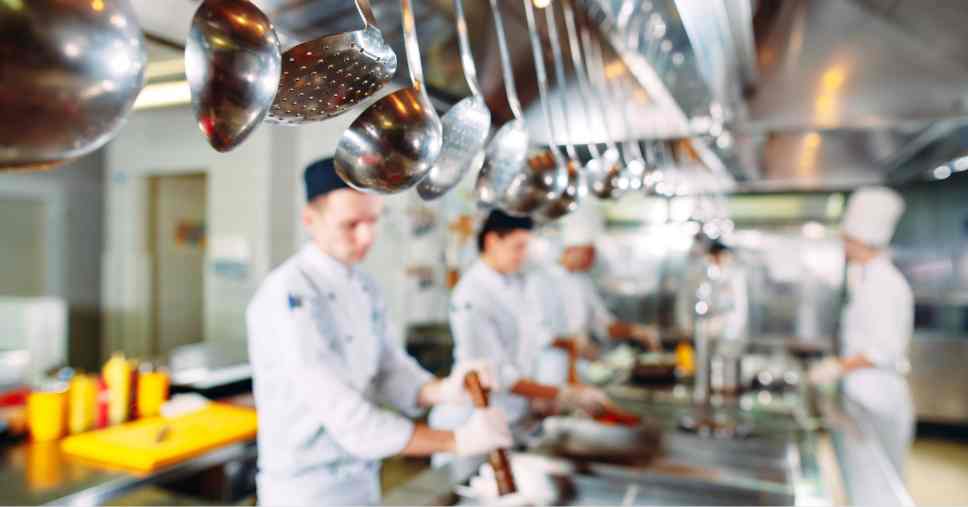 Cozinheiros trabalham em ambiente higienizado para a sanitização de restaurante.