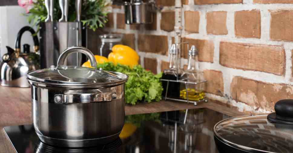 Panelas em fogão limpo ilustram o cuidado para eliminar baratas da cozinha.