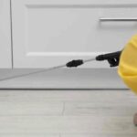 Aplicador especializado com pulverizador junto à base de um armário para combater cupim em móveis.